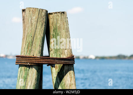 Nahaufnahme der Anker Holz- Poller auf dem Boot Pier in Fort Myers Florida mit Bucht von Blue Water Stockfoto