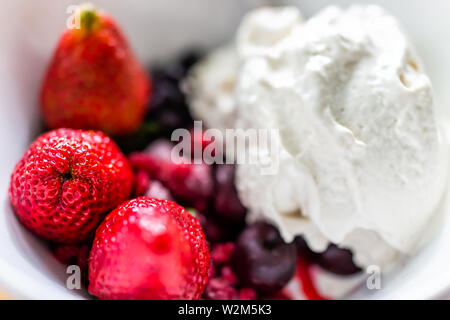 Makro Nahaufnahme von bunten Schüssel mit Vanilleeis garniert mit frischen roten Erdbeere großen Beeren Stockfoto