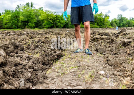 Mann Beine wandern auf der Suche nach Mineralien brauner Boden in Arkansas Schmutz Landschaft wiese feld im Krater des Diamanten State Park Stockfoto