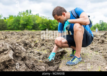 Der Mensch auf der Suche nach Edelsteinen berühren brauner Boden in Arkansas Schmutz Landschaft wiese feld im Krater des Diamanten State Park Stockfoto