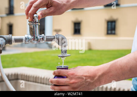 Hot Springs, USA Badehaus Zeile mit dem Mann auf der Straße in der Stadt closeup gießen Mineral gesundes Wasser in die Flasche am Brunnen Stockfoto