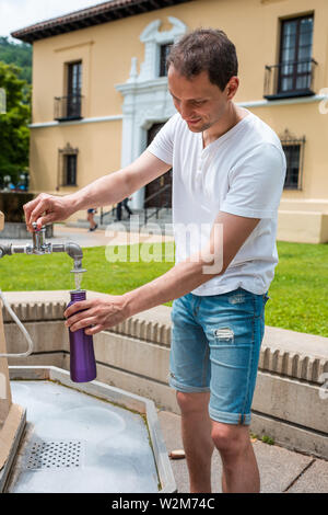 Hot Springs, USA historische Whirlpool Haus Zeile mit dem Mann auf der Straße in der Stadt Gießen mineral gesundes Wasser in die Flasche am Brunnen Stockfoto