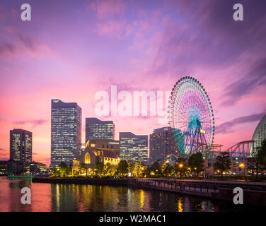 Eine Aussicht auf eine brillante Sonnenuntergang über der Yokohama Skyline bei minato-mirai und der Cosmo Wecker 21 Riesenrad, wie vom VN-Park gesehen. Yokohama, Japan. Stockfoto