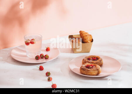 Sweet Summer Dessert hausgemachte gebackene mini Croissants, serviert mit kalten Himbeere Apfelwein, frischen Himbeeren. Auf einem weißen Marmor Tabelle, kopieren Raum oben vie Stockfoto