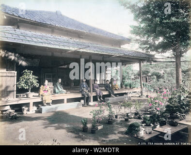 [1880s Japan - Japanischer Garten mit Miniatur Bonsai Bäume] - Bonsai (Miniatur Bäume in Containern) in Tokyo Garden. Die Leute sitzen auf der engawa der traditionellen Haus. Kann auch ein Vogelkäfig gesehen werden. 19 Vintage albumen Foto. Stockfoto