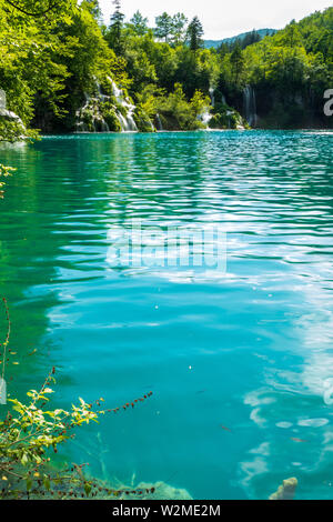 Rauschende Wasserfälle, die natürliche Hindernisse in den glasklaren und azurblauen See Milanovac im Nationalpark Plitvicer Seen, Kroatien Stockfoto