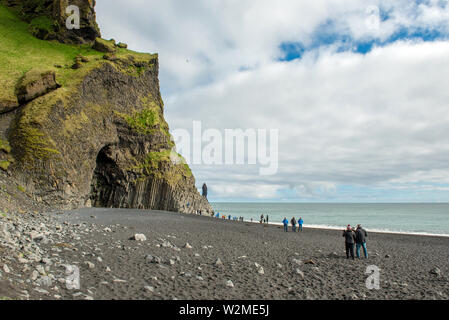 VIK, ISLAND - 21. MAI 2019: Touristen, die in der Strand Reynisfjara und die Basaltsäulen, die an der Atlantikküste der südlichen Island in Vik Stockfoto