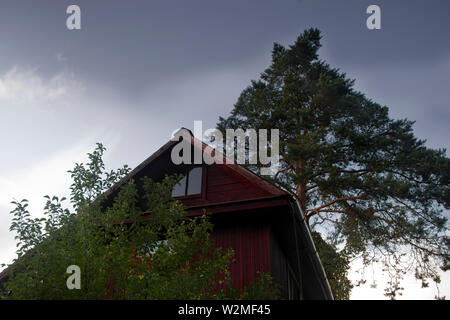 Die stürmischen Himmel Regen hinter einem Holzhaus, Low Angle Shot im Freien Stockfoto