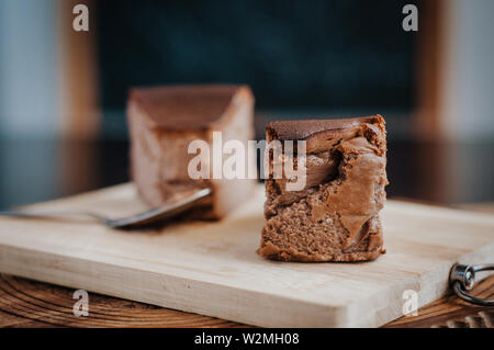Schokolade Käsekuchen auf braunem Holz- Hintergrund verbrannt. selektive Fokus Stockfoto