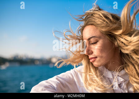 Attraktive junge schöne Mädchen genießt Moment während der Kreuzfahrt mit Blick auf das Meer im Hintergrund. Lifestyle Konzept Stockfoto