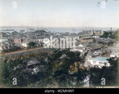 [1880s Japan - Blick auf die Yokohama des fremden Siedlung] - Blick auf Motomachi, Yokohama ausländische Siedlung und Yokohama Hafen von motomachi Hyakudan an Sengenzaka in Yokohama, Kanagawa Präfektur einige Zeit in den 1880er Jahren. Im Vordergrund ist Motomachi, wo die ursprüngliche Dorfbewohner von Yokohama wurden umgesiedelt. Zotokuin Tempel ist sichtbar auf der rechten Seite. Auf der anderen Seite des Kanals ist die Horikawa Yamashita Siedlung. Die längliche Gebäude an der Küste ist das Grand Hotel, das im Jahre 1887 gebaut wurde (meji 20). 19 Vintage albumen Foto. Stockfoto