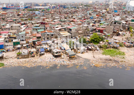 Slums in Manila, eine Sicht von oben. Meeresverschmutzung durch Hausmüll. Plastikmüll am Strand. Stockfoto