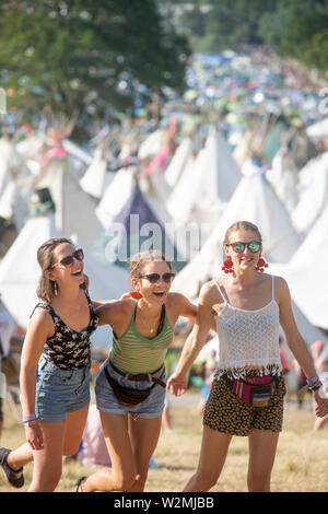 Festival - goers​ posieren für ein Foto über dem Tipidorf an Glastonbury 2019 Stockfoto