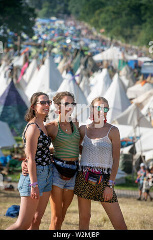 Festival - goers​ posieren für ein Foto über dem Tipidorf an Glastonbury 2019 Stockfoto