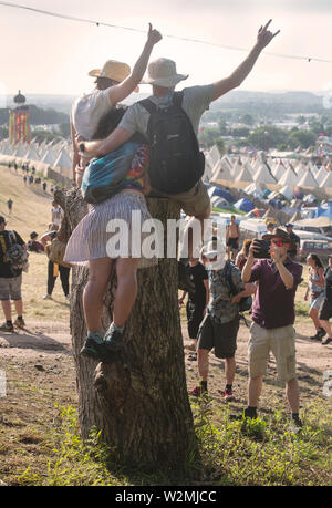 Festivalbesucher posieren für ein Foto über dem Tipidorf an Glastonbury 2019 Stockfoto