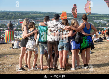 Festivalbesucher posieren für ein Foto über dem Park und Ribbon Turm in Glastonbury 2019 Stockfoto