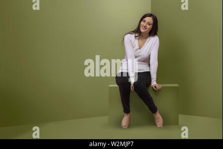 Studio geschossen von lächelnden jungen Teenager in Jeans für Fotos posiert Stockfoto