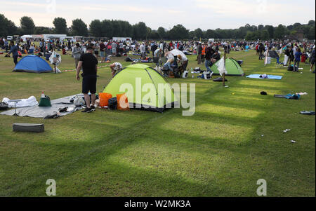 Menschen, die ihre Zelte nach Camping in Wimbledon Park am Tag neun der Wimbledon Championships in der All England Lawn Tennis und Croquet Club, London. Stockfoto