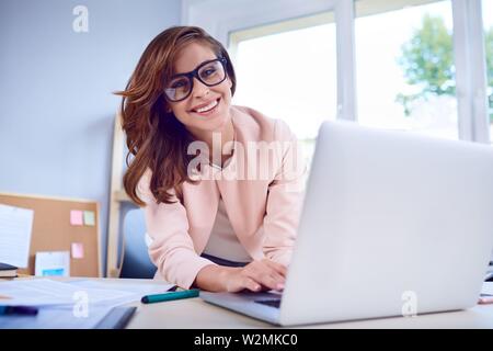 Portrait von Happy Geschäftsfrau Arbeiten am Laptop Stockfoto