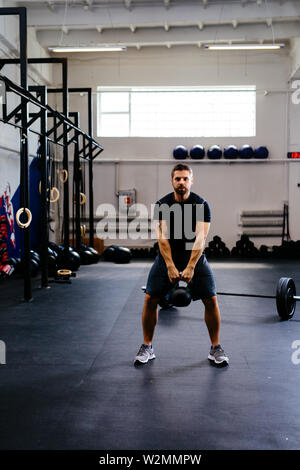 Portrait von athletischen Mann tun kettlebell Schaukeln Stockfoto