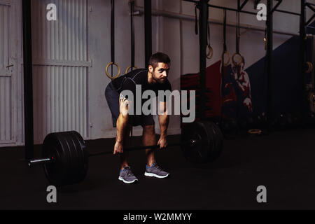 Junger Mann, Kreuzheben Übung im Fitnessstudio Stockfoto