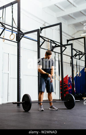 Schöner mann Vorbereitung vor dem Anheben barbell in der Turnhalle Stockfoto