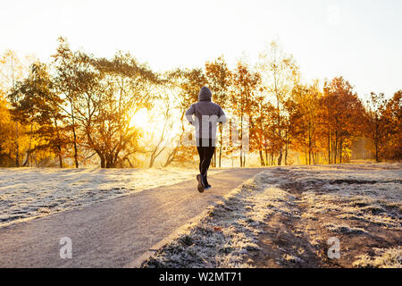 Mit Kapuze Mann Joggen im Park auf sonnigen Herbst morgen Stockfoto