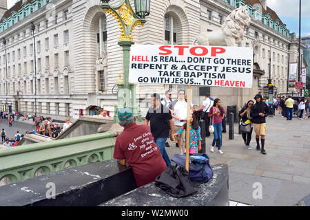 London, England, UK. Religiöse Spoiler mit einem Plakat auf die Westminster Bridge, die County Hall. Stockfoto