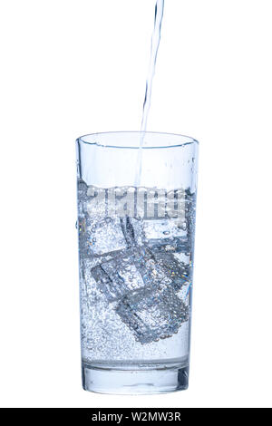 Das Gießen von Mineralwasser in transparentem Glas mit Eis und Blasen auf weißem Hintergrund, in der Nähe Stockfoto