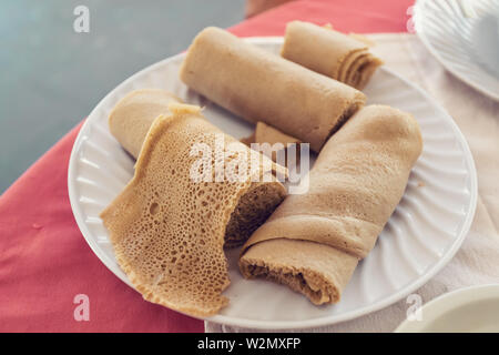 Injera Essen, traditionelle und nationale Gericht aus Äthiopien und Eritrea. Mahlzeit, bestehend aus injera und verschiedene Arten von Wat oder tsebhi (Eintopf) oder (maraq), Ty Stockfoto