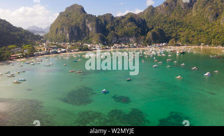 Viele Boote in die türkisfarbene Lagune. Meereslandschaft mit Blue Bay und Boote Blick von oben. El Nido, Palawan, Philippinen. Traditionelle philippinische Holz- Auslegerboot, das die Banca genannt. Sommer und Reisen Urlaub Begriff Stockfoto