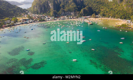 Viele Boote in die türkisfarbene Lagune. Meereslandschaft mit Blue Bay und Boote Blick von oben. El Nido, Palawan, Philippinen. Traditionelle philippinische Holz- Auslegerboot, das die Banca genannt. Sommer und Reisen Urlaub Begriff Stockfoto