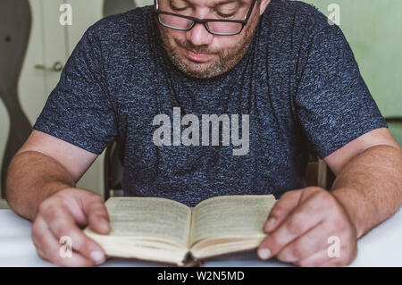 Man liest ein Buch auf dem Tisch, einen Snack beim Lesen, eine kurze Pause Stockfoto