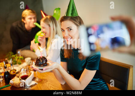 Foodblogger nimmt Bilder von einem Stück Kuchen an einem Geburtstag Stockfoto