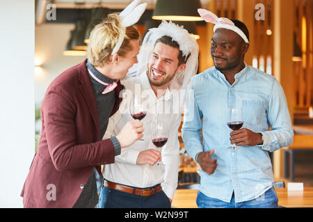 Freunde in lustiger Verkleidung einen Junggesellenabschied in einer Bar feiern. Stockfoto