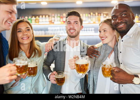 Eine Gruppe von Freunden in Bier zusammen in der Kneipe oder Bar nach der Arbeit Stockfoto