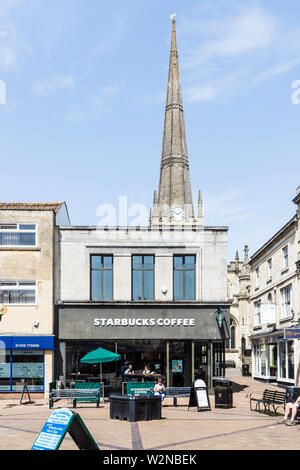 Starbucks Cafe im Freien und der Kirchturm von St. James hinter sich gegen einen blauen Sommerhimmel in Chippenham Wiltshire Stockfoto