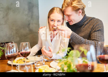 Ein junges Paar, das Spaß mit Mittag- oder Abendessen im Restaurant Stockfoto