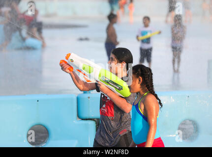 New York, USA. 9. Juli 2019. Kinder spielen mit Wasser im Brunnen um die Unisphere im Flushing Meadows Corona Park in New York, USA, 9. Juli 2019. Als der Sommer kommt, spielt Wasser wird sehr beliebt rund um die Stadt. Credit: Wang Ying/Xinhua/Alamy leben Nachrichten Stockfoto