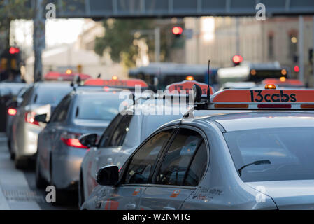 Eine Linie von Taxis warten mit ihrem Licht auf außerhalb eines Gebäudes in Sydney am frühen Abend Stockfoto