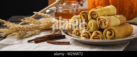 Kürbis Pfannkuchen mit Honig und Zimt auf einem Holztisch. Stockfoto