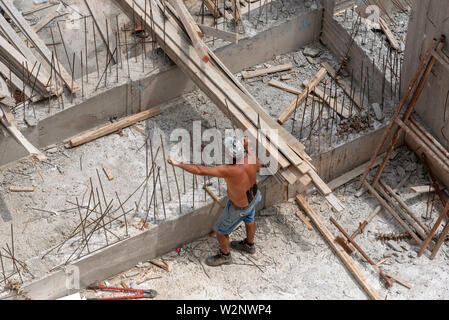 Kreta, Griechenland. Juni 2019. Ein Bauherr auf der Baustelle arbeiten mit recycelten Holzbohlen Stockfoto