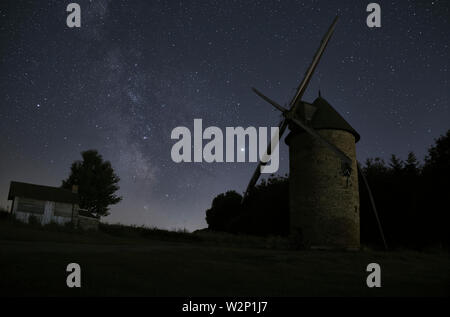 Eine alte restaurierte Mühle in der Nacht vor dem Hintergrund einer sternenklaren Nacht mit der Milchstraße. Stockfoto