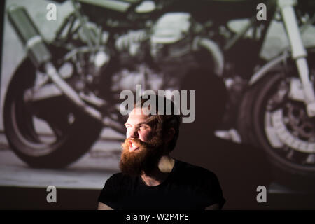 Bis zu schließen. Porträt einer charismatischen Mann Biker auf dem Hintergrund der Motorrad. Stockfoto