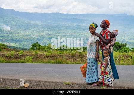 Zwei junge Frauen, die ein kleines Kind auf dem Weg zu einem Markt in der Nähe von Mizan Teferi, Sitzbank Maji, Äthiopien Stockfoto