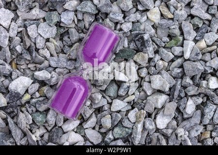 Die Sanduhr ist ein Symbol der Zeit liegend auf kleinen Steinen Stockfoto