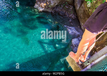 Mann bereit, von der Drehbrücke auf blauen Pool in Wanaka, Neuseeland zu springen. Stockfoto