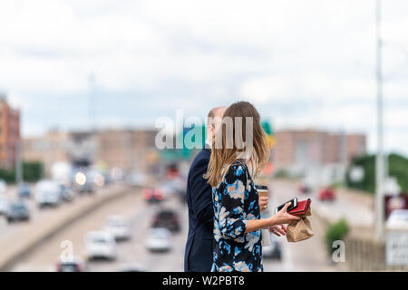 Dallas, USA - Juni 7, 2019: Bokeh Hintergrund der Landstraße im Ort Woodall Rodgers Freeway und paar Kollegen wandern mit Mittagessen Stockfoto