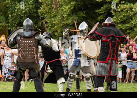 Nis, Serbien - Juni 15. 2019 Ritter kämpfen in der Gruppe Schlachten mit Schwertern und Bügeleisen Waffe in schützende Rüstung und Helm. Wiederaufbau der Ritter Schlacht Stockfoto