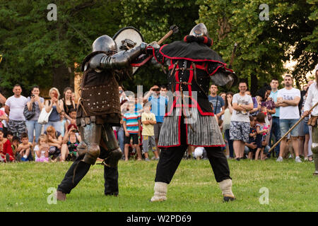 Nis, Serbien - Juni 15. 2019 Zwei große Ritter in schützende Rüstung Kampf auf dem Schlachtfeld. Wiederaufbau der Ritter Schlachten auf dem Festival Stockfoto